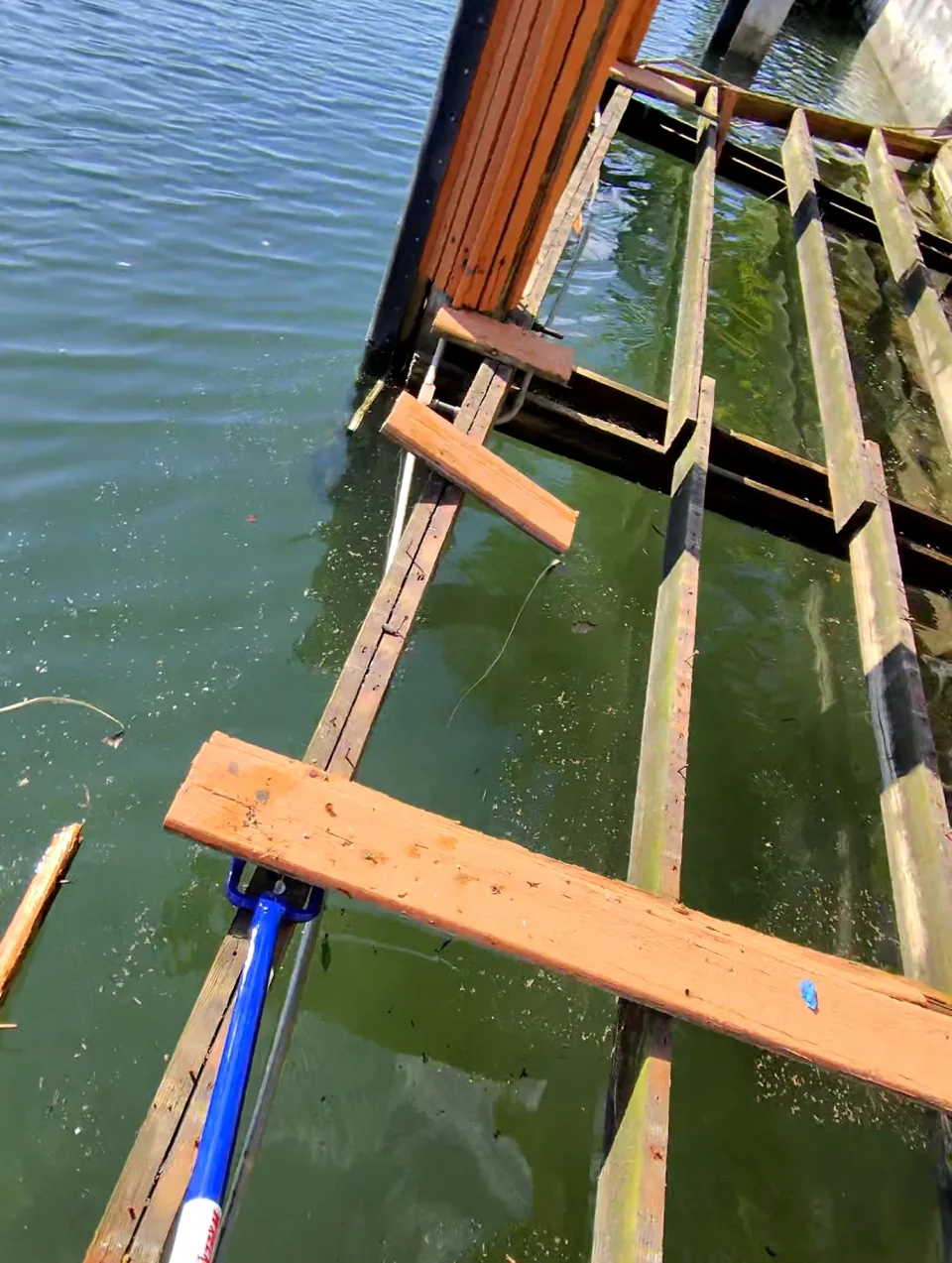Crew prying up deck boards with the framing exposed underneath