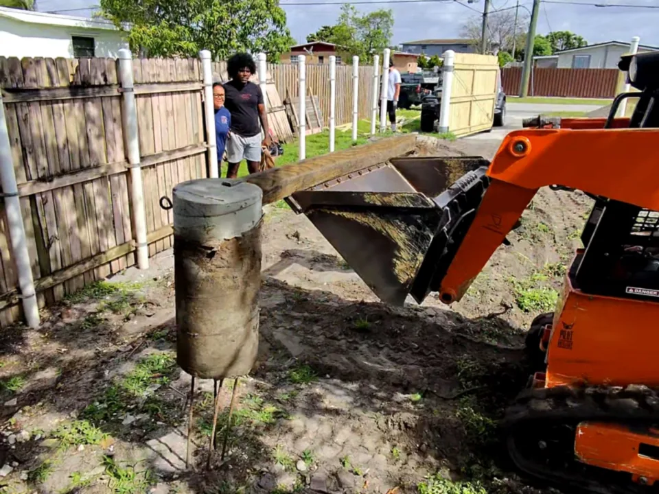 Pulled fence posts with concrete footings stacked for loading