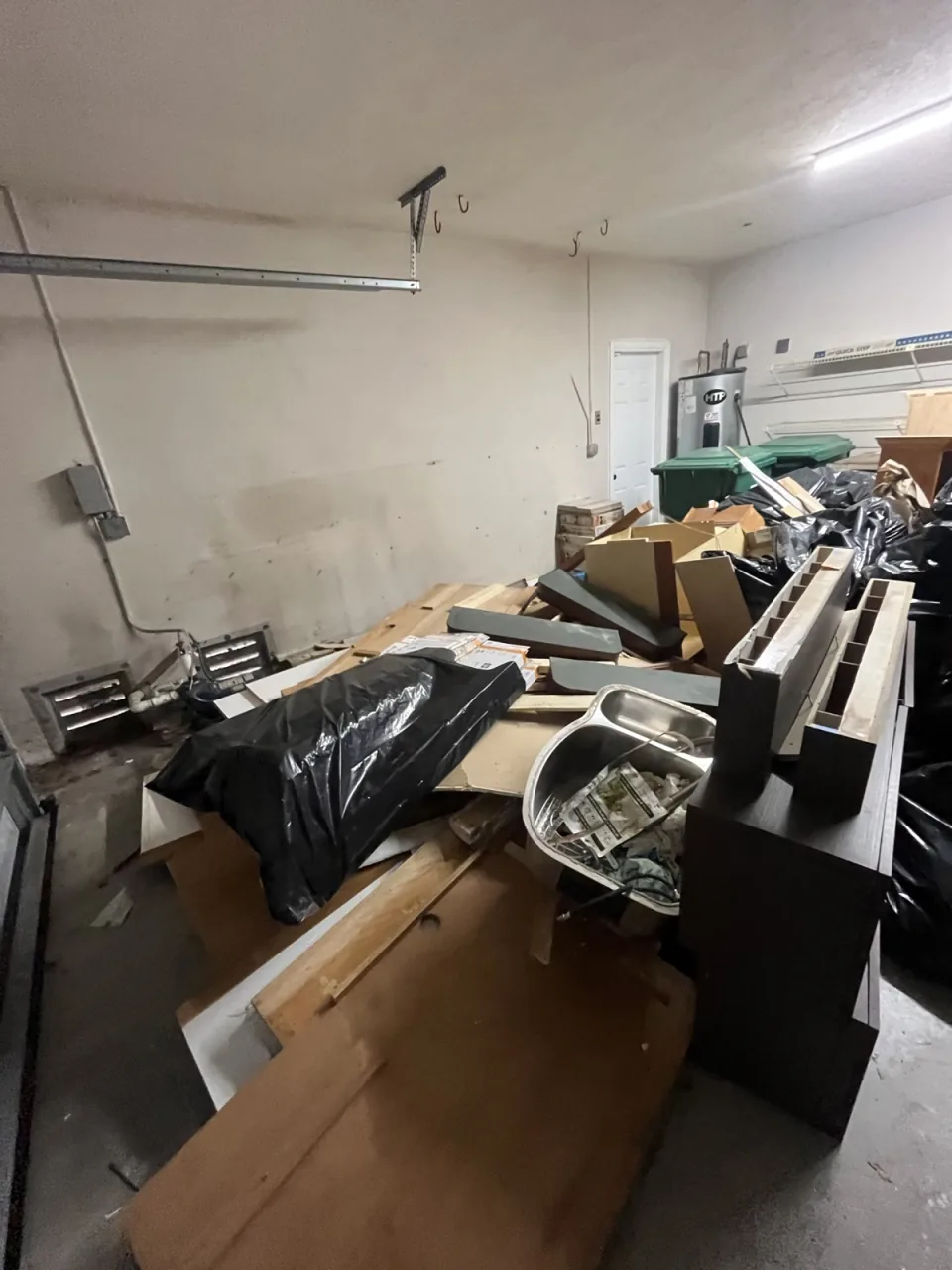Cluttered garage packed with boxes, furniture and junk before a cleanout