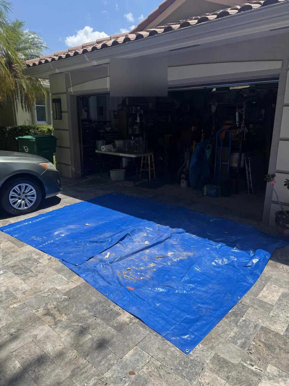 Open garage door showing boxes and clutter before a cleanout