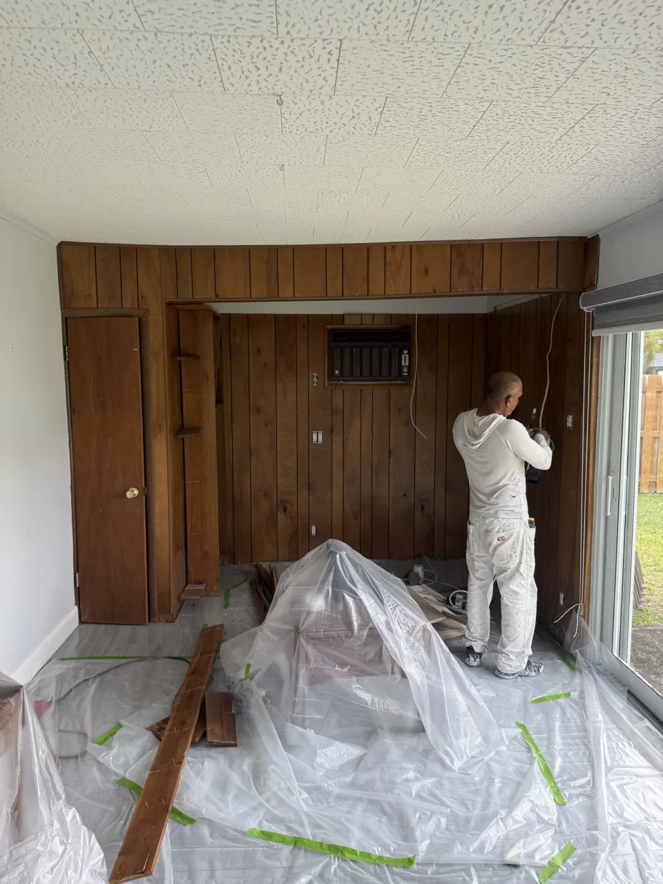 Crew member pulling old tile and fixtures out of a bathroom