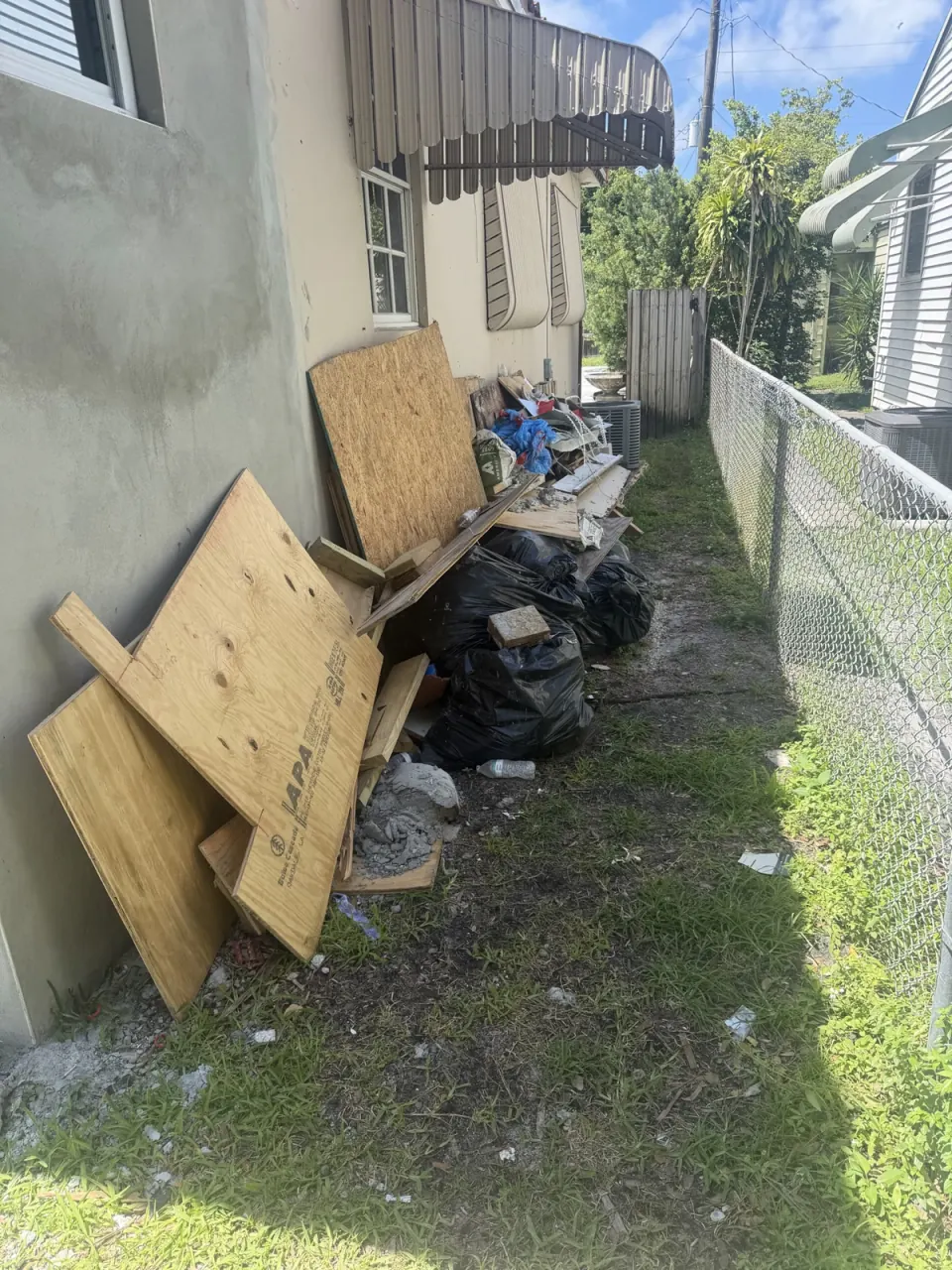 Side yard cleared of brush and debris, with the ground raked bare